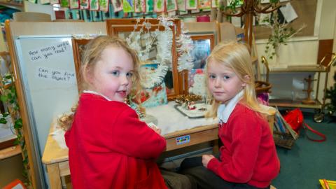 Two girls sat at a desk in the early years classroom